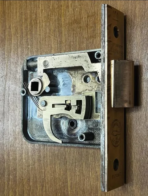 The inside of a brass mortice lock, levers and bolt visible