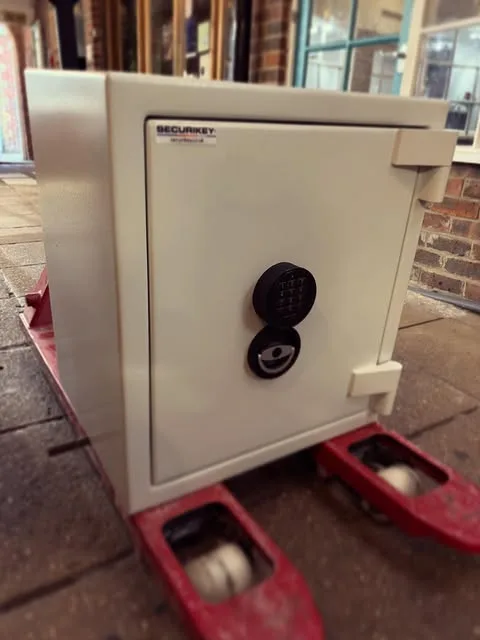 A SecuriKey safe on a pallet truck outside a brick building, ready to install